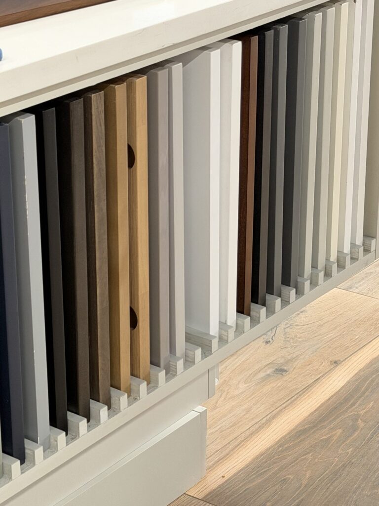 Wall of cabinet door samples in painted, natural wood and stained finishes at the Alliance Construction showroom in Fort Myers