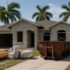 Concrete-block home in Estero, Florida undergoing a whole-home remodel with scaffolding, dumpster and staged materials
