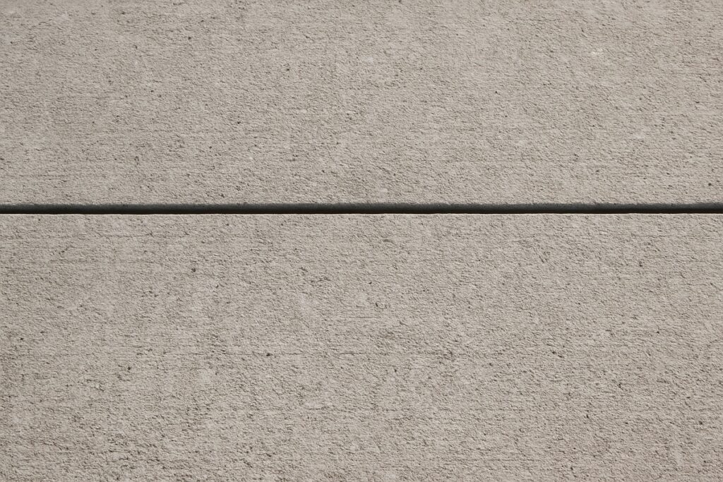 Close-up of a poured concrete driveway with a control joint