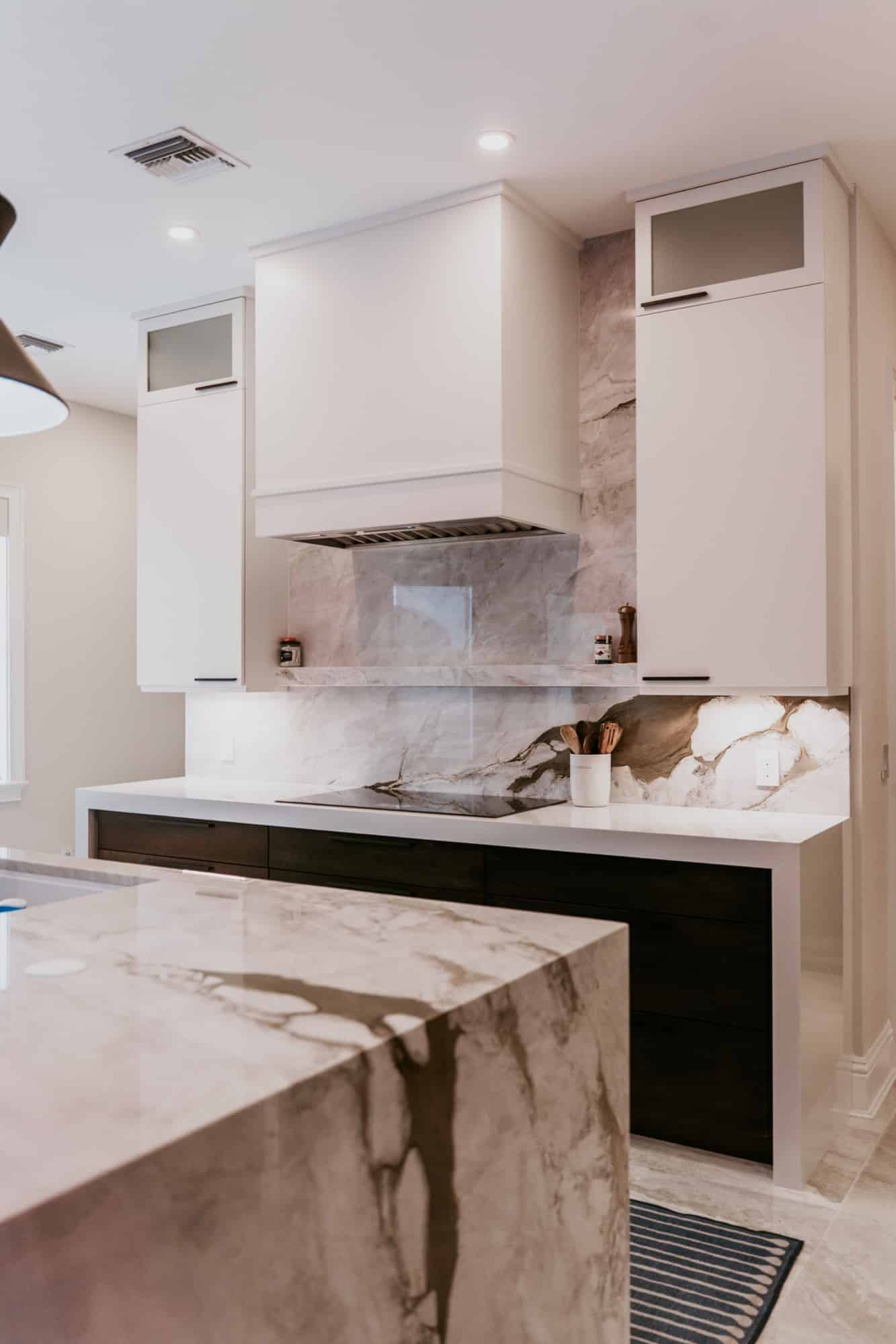 Kitchen cooktop wall with vent hood and full-height cabinetry, Alliance Construction project