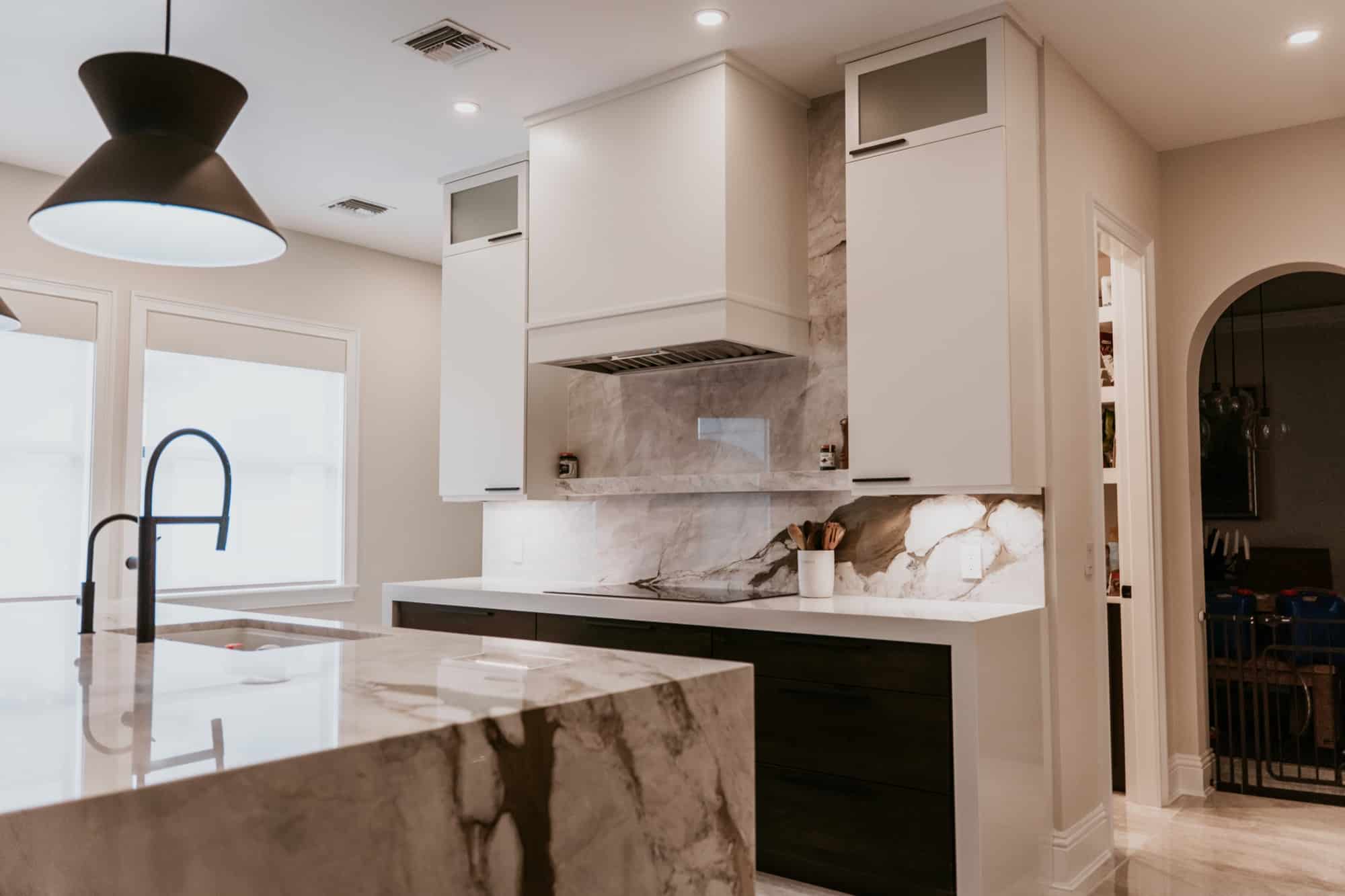 Finished built interior with stone backsplash, custom cabinetry and adjacent pantry, Alliance Construction project
