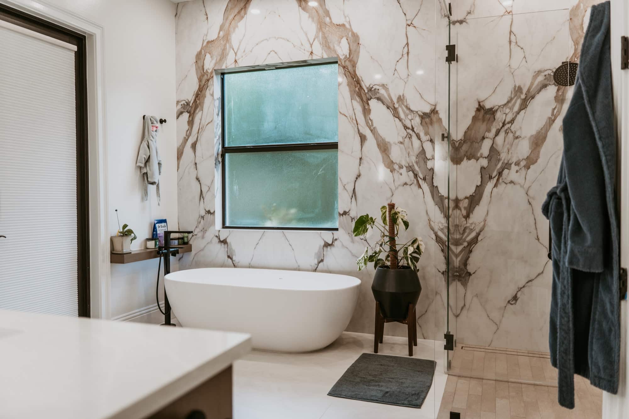 Remodeled bathroom with freestanding tub and marble surround, Alliance Construction project