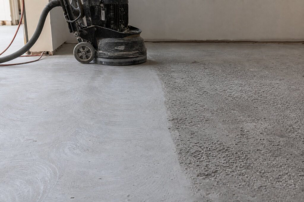 Concrete garage floor being ground in preparation for epoxy