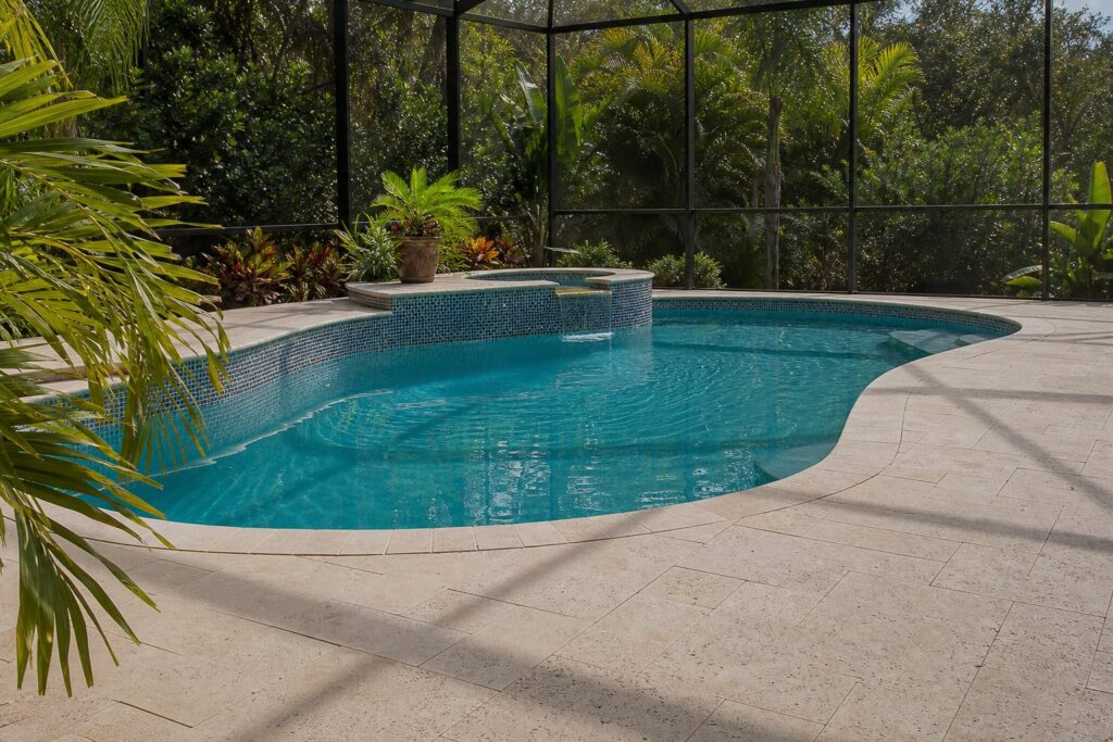 Travertine pool deck pavers beside a screened Florida lanai