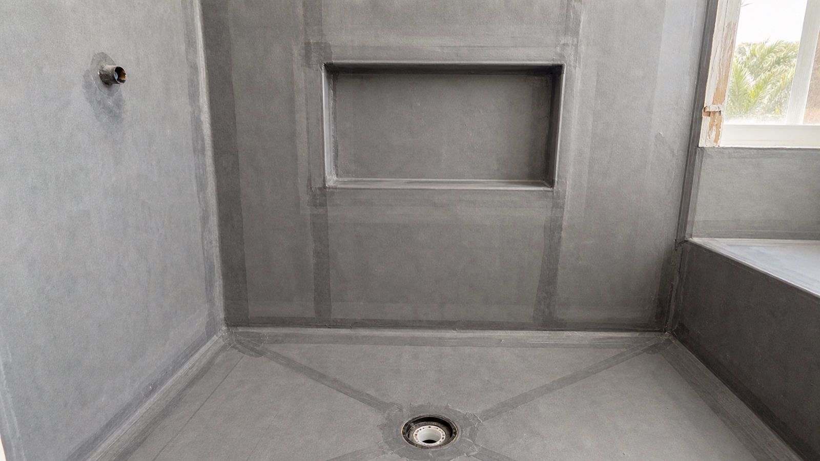 Recessed shower niche integrated into gray sheet waterproofing before tile