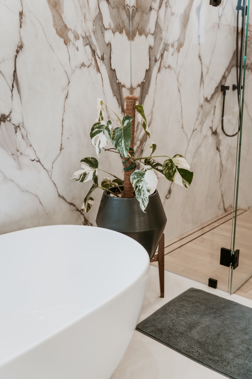 Marble-look tile veining aligned beside a freestanding tub