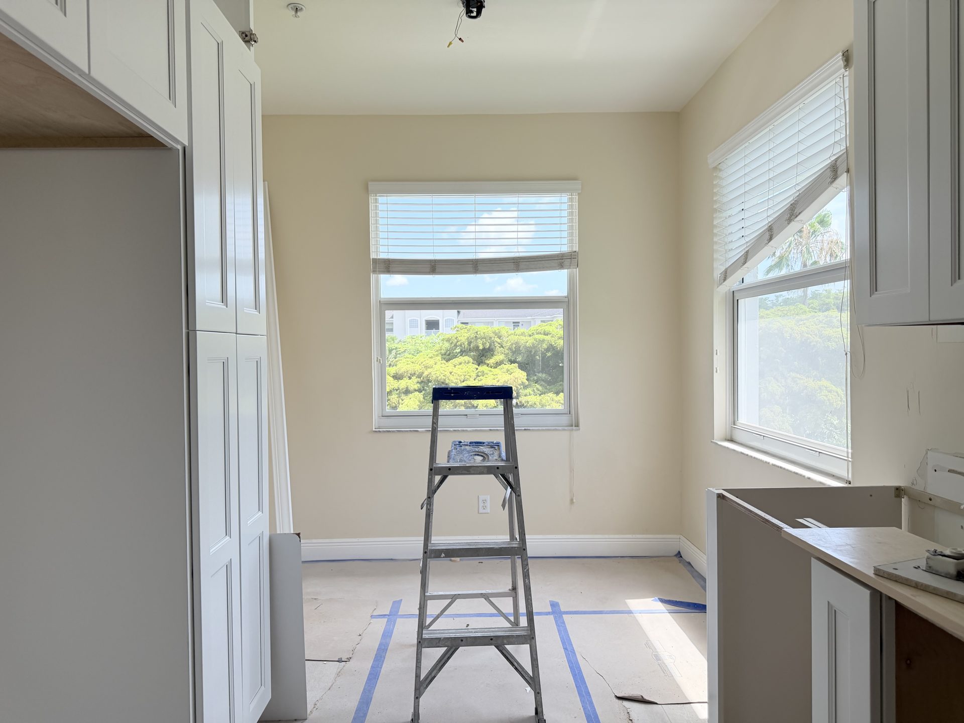 Kitchen cabinet runs installed around a window during a Fort Myers remodel, counters pending