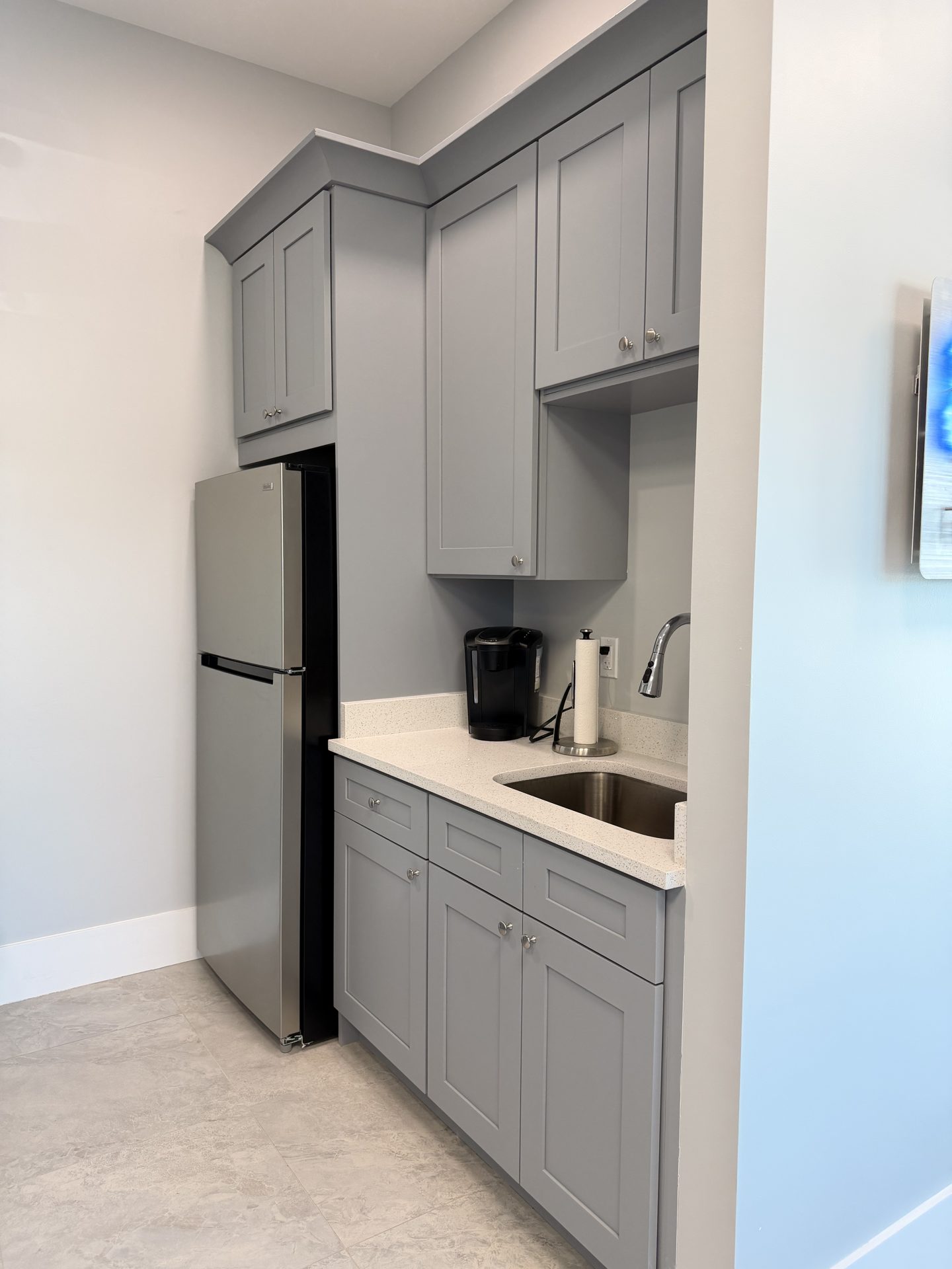 Second angle of the gray shaker kitchenette sink run with white quartz counters