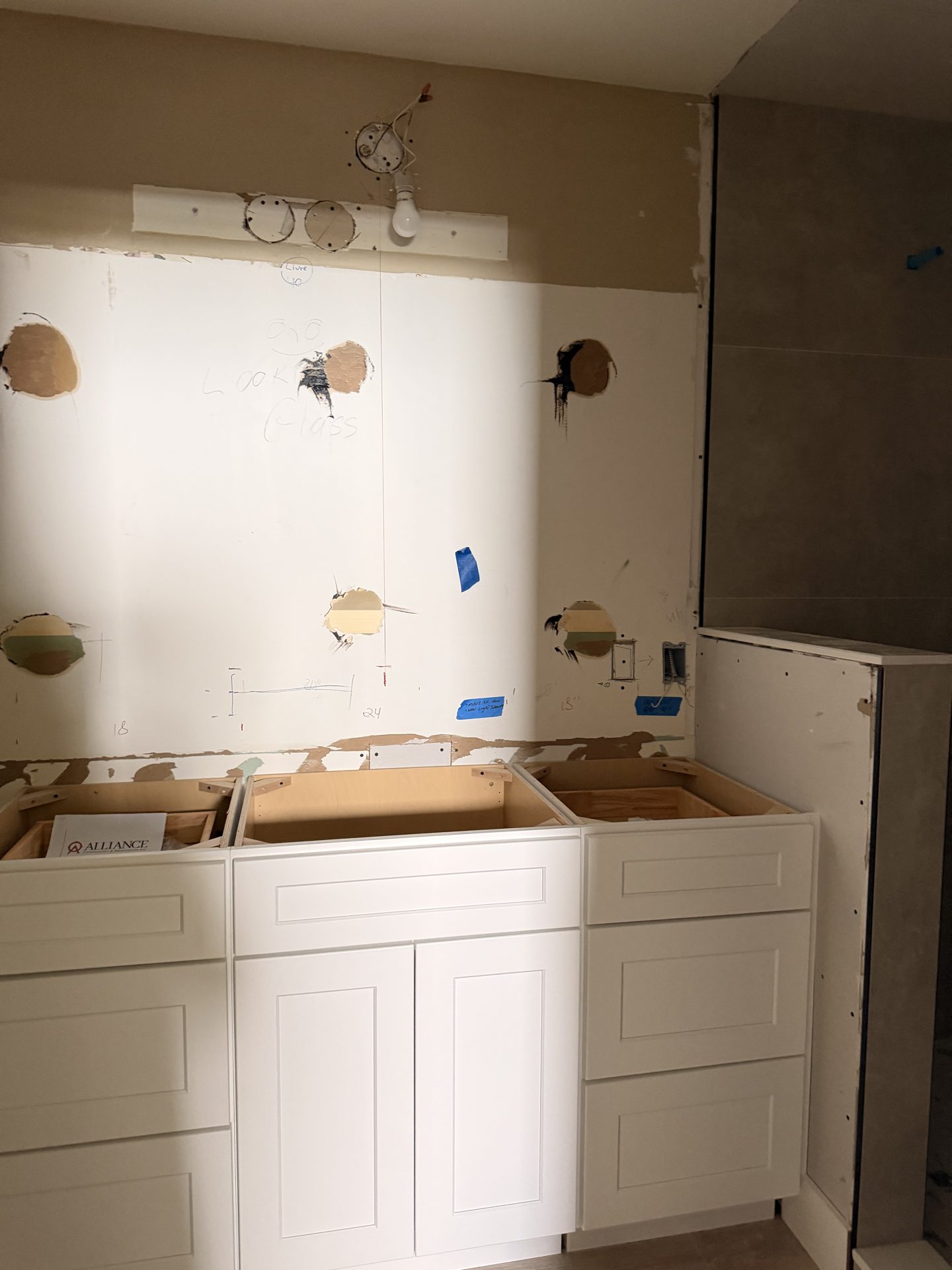 White laundry base cabinets installed with tile wall up one month later