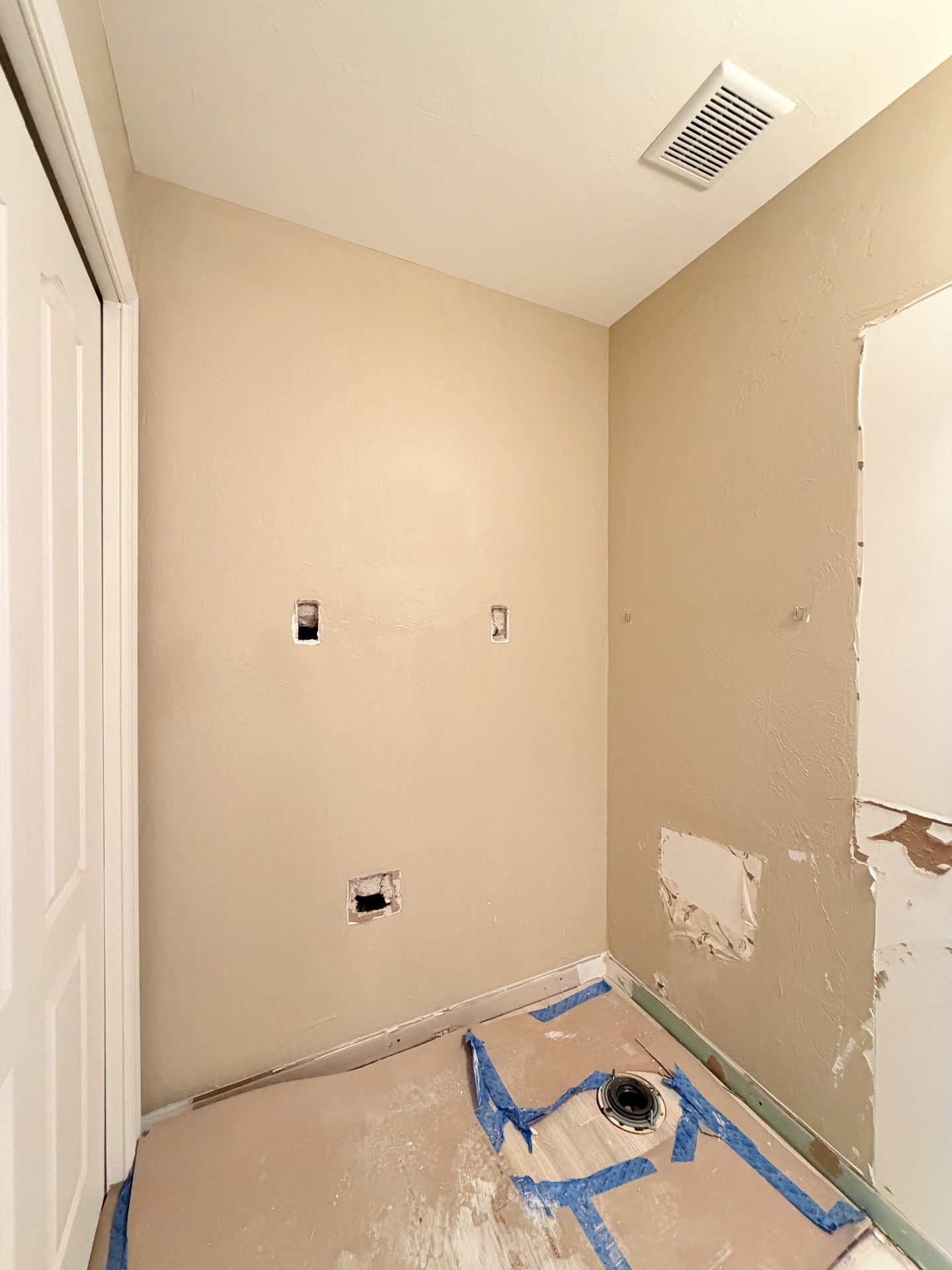 Laundry room stripped to patched drywall during demolition in June
