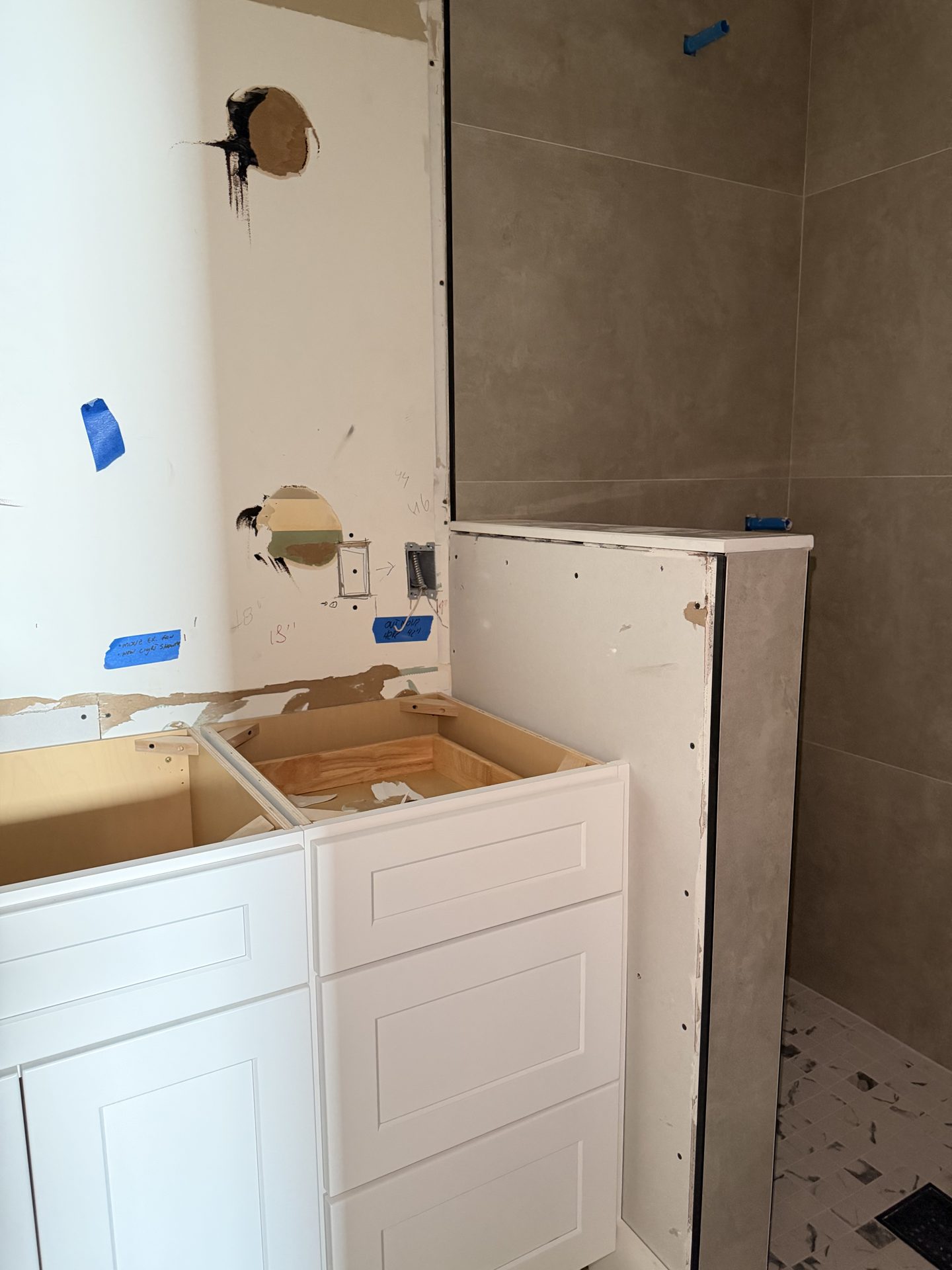 Laundry room tile wall and cabinet corner with plumbing rough in during remodel