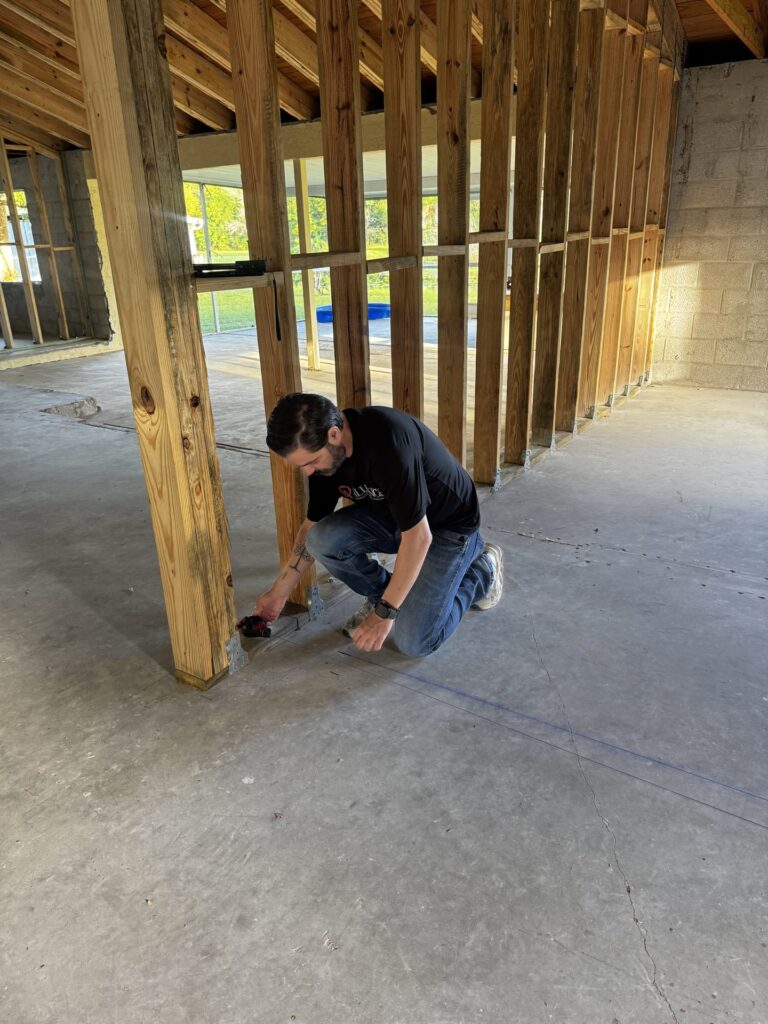 Alliance crew member working on new wall framing inside the home