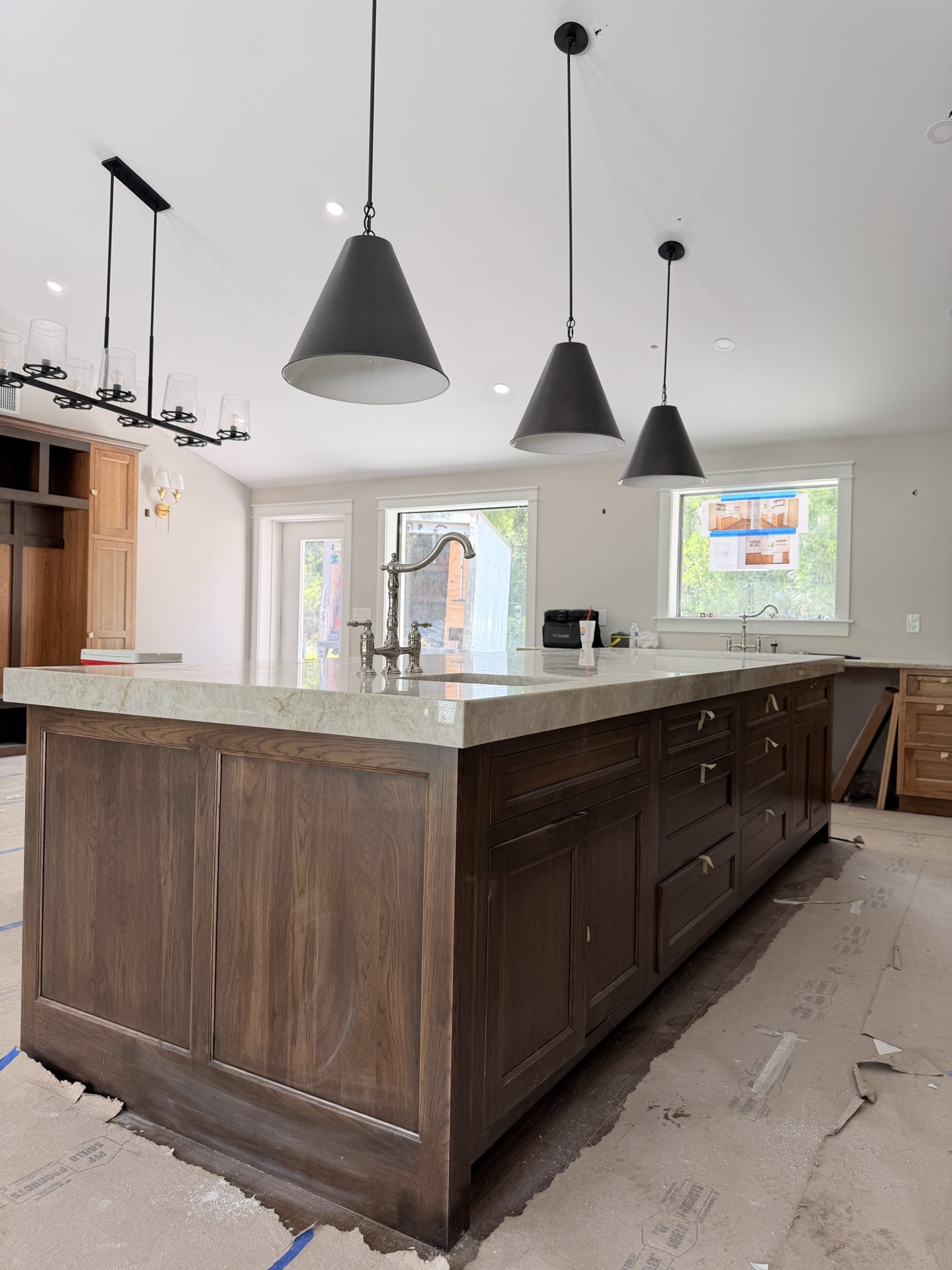 Large custom kitchen island under black cone pendant lights during a Fort Myers whole home renovation