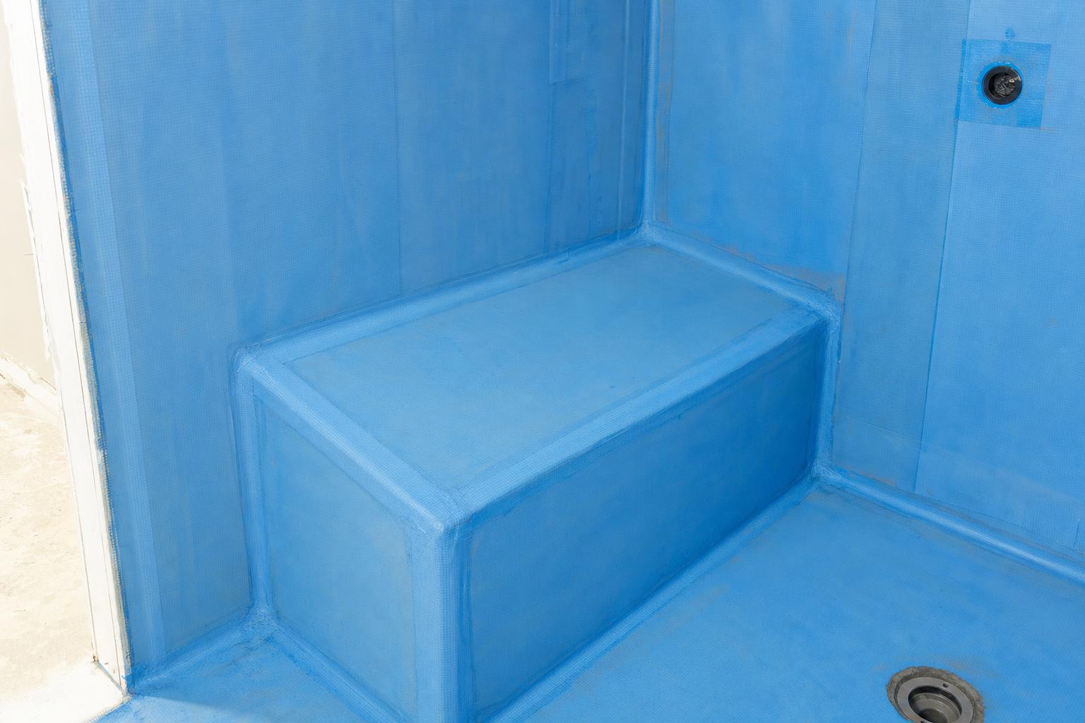 Shower bench wrapped in waterproofing before tile installation