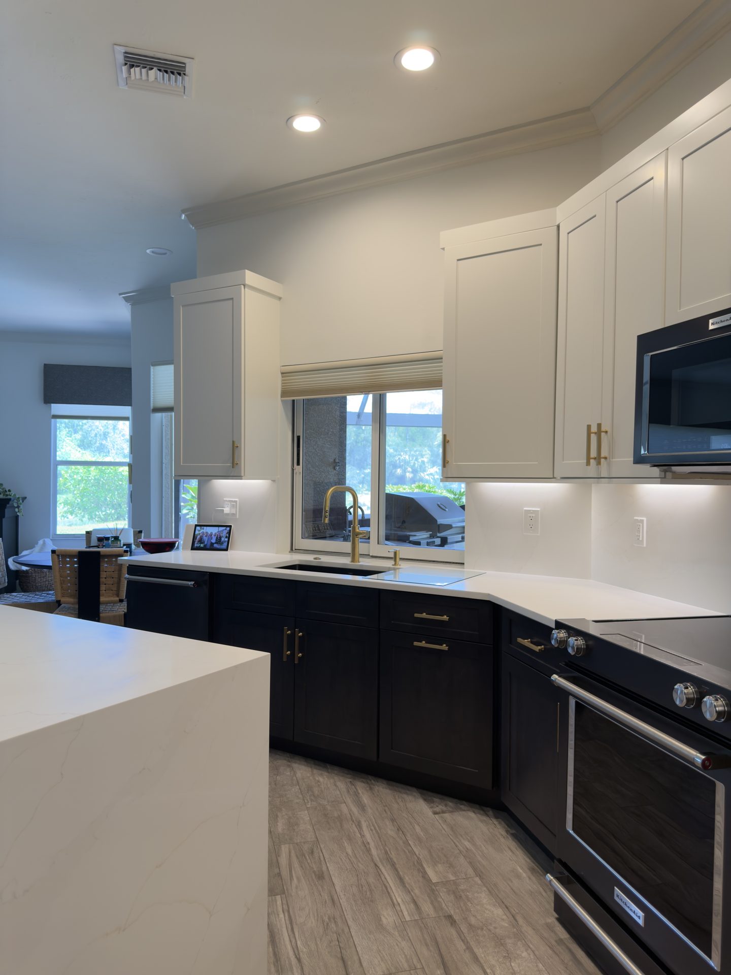 Two tone kitchen sink and window wall with white uppers, espresso lowers and quartz counters