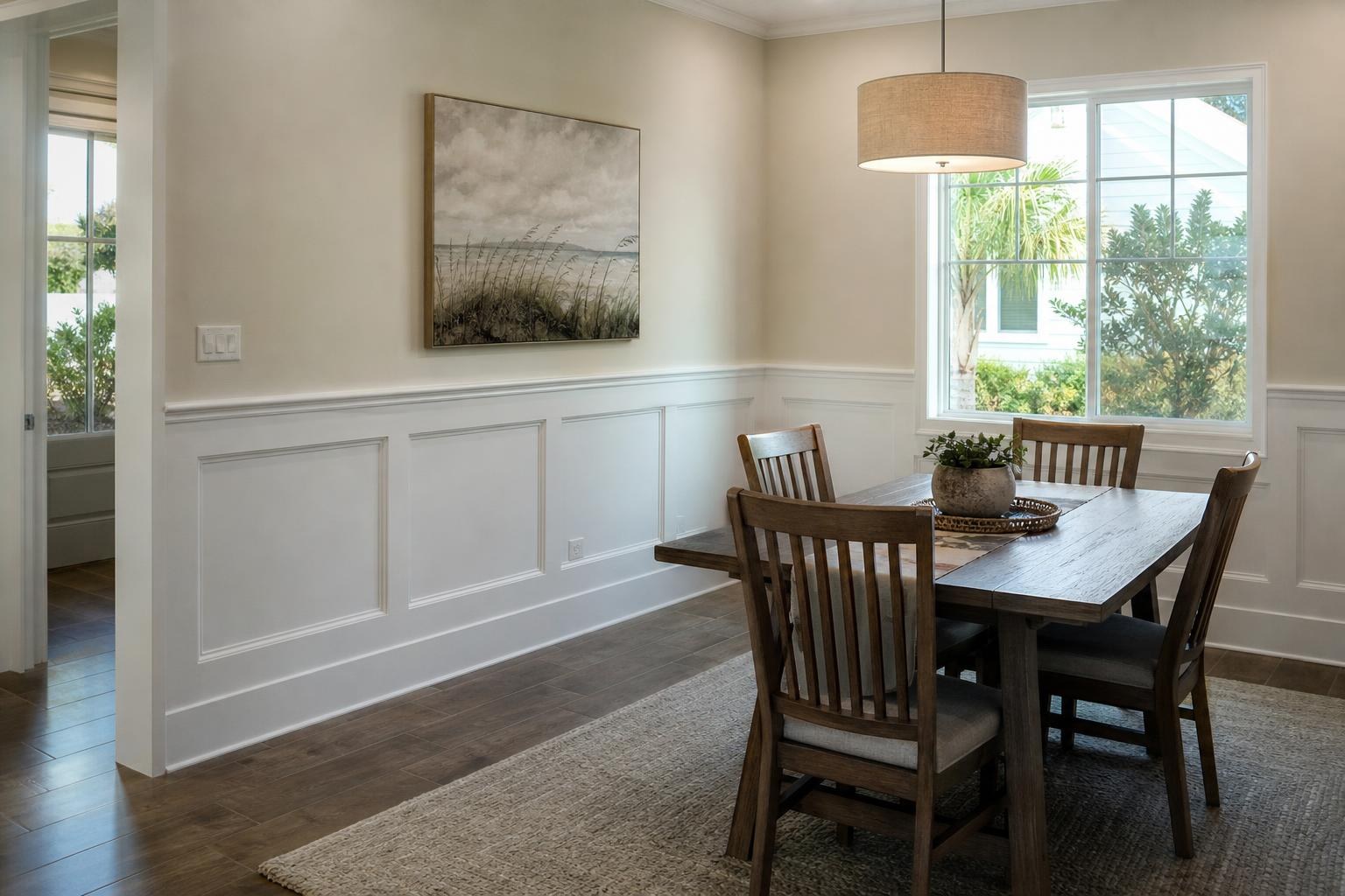 Dining room with white paneled wainscoting below a chair rail and warm white walls above